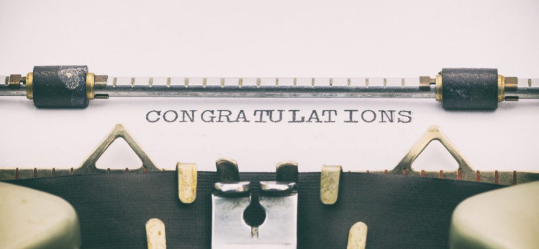 Close-up of congratulations word in capital letters on white paper in typewriter